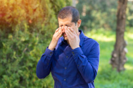 man covering his eyes with hand to shield from the sunlight