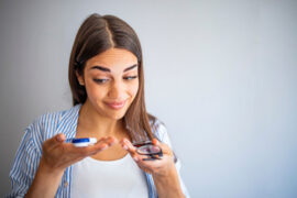 Woman choosing between contact lenses and glasses