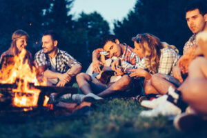 young people sitting around a campfire